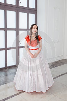 Beautiful woman in white and red medieval dress with crinoline