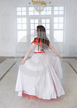 Beautiful woman in white and red medieval dress with crinoline. Back pose