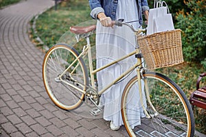 Beautiful woman with white shopping bags in basket on vintage bicycle