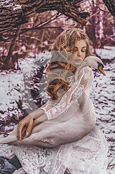 Beautiful woman with white swan in nature photoshoot portrait