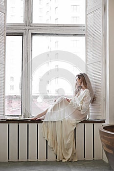 Beautiful woman in white underwear and negligee at home in the bathroom. A woman in love is resting