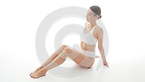 Beautiful woman in white underwear over isolated white background. Studio video of healthy young girl in swimsuit