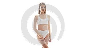 Beautiful woman in white underwear over isolated white background. Studio video of healthy young girl in swimsuit