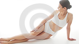 Beautiful woman in white underwear over isolated white background. Studio video of healthy young girl in swimsuit