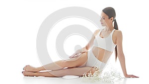 Beautiful woman in white underwear over isolated white background. Studio video of healthy young girl in swimsuit