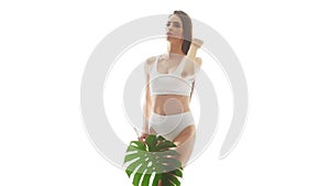 Beautiful woman in white underwear over isolated white background. Studio video of healthy young girl in swimsuit