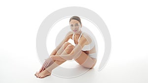 Beautiful woman in white underwear over isolated white background. Studio video of healthy young girl in swimsuit