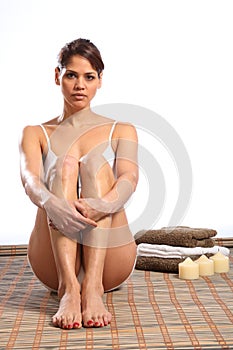 Beautiful woman in white underwear sitting on mat