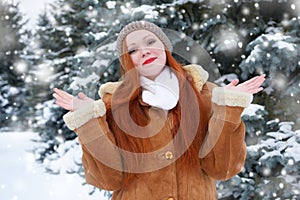 Beautiful woman on winter outdoor, snowy fir trees in forest, long red hair, wearing a sheepskin coat