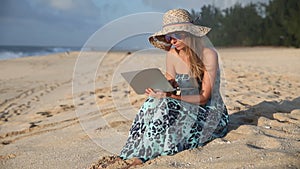 Beautiful Woman Working On Laptop on the Beach