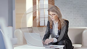 Beautiful woman working on laptop in expensive office, responsible employee