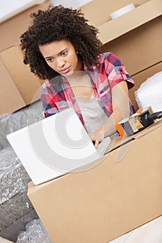 Beautiful woman working with laptop during office relocation