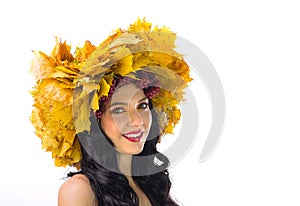 Beautiful woman in wreath of autumn leaves and guelder-rose on w