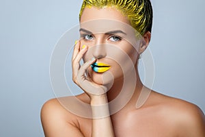 Beautiful woman with yellow hair and colorful nails and lips