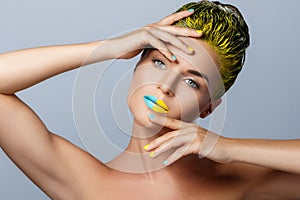 Beautiful woman with yellow hair and colorful nails and lips