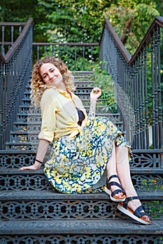 Beautiful woman in a yellow shirt on the stairs