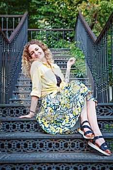 Beautiful woman in a yellow shirt on the stairs