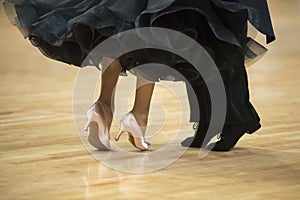 Beautiful womanish and masculine legs in active ballroom dance,