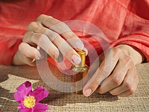 Beautiful womans hands holding a small vial of scented oil. Arab Attar.