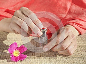 Beautiful womans hands holding a small vial of scented oil. Arab Attar.