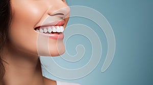 Beautiful womans smile with healthy white, straight teeth close-up on light-blue background with space for text