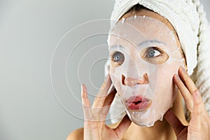 Beautiful women applying facial mask with moisturizer