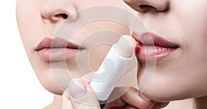 Beautiful woman applying hygienic lip balm.