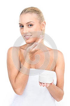 Beautiful women applying moisturizer cosmetic cream on face.