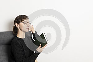 Beautiful women with book sitting in chair and correct her glasses. education concept. student learning literature