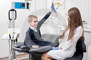 Beautiful woman dentist giving his little patient a high five