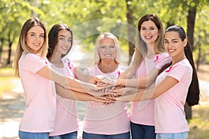 Beautiful women of different ages with pink ribbons outdoors. Breast cancer concept