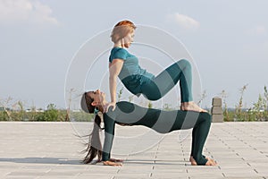 Beautiful women exercizing yoga together on the nature. Concept of relationship, love, summer, weekend, honeymoon, healthy