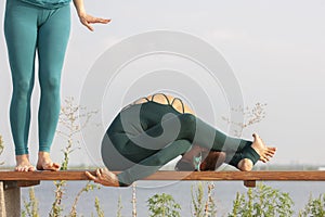 Beautiful women exercizing yoga together on the nature. Concept of relationship, love, summer, weekend, honeymoon, healthy