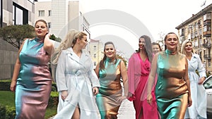 Beautiful women in fashion dresses defile on the street. Plus size Fashion Week. Slow motion.