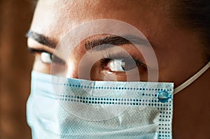 Beautiful Women In A Medical Mask. Close-up of a young girl with a surgical mask on her face against SARS-cov-2