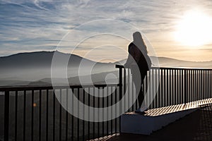 Beautiful women standing at a viewpoint on a cliff during sunset