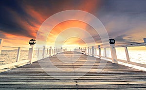 beautiful wood pier against dramatic sunset sky