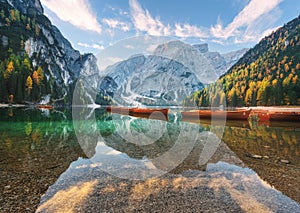 Beautiful wooden boats on Braies lake at sunrise in autumn