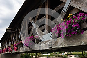 Wooden Covered Bridge with Colorful Flowers over the DuPage River along the Naperville Riverwalk in Suburban Naperville Illinois d photo