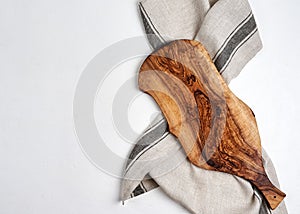 Beautiful wooden kitchen background cutting board over kitchen towel on white table background, top view