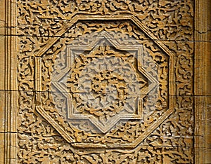 Beautiful wooden octagonal star rosette with floral pattern - details of medieval Karakhanid `s tomb door in Uzgen,Osh Region, Ky