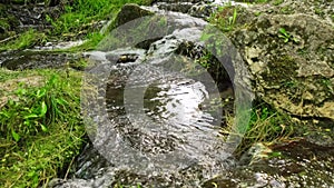 Beautiful woodland stream in summer. Waterfall in deep forest.