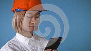 Beautiful worker in uniform texting on mobile