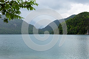 Beautiful wow Postcard view of Alpsee Lake surrounded by Alps mountains, Bavaria, Germany. Spring summer time. Blue
