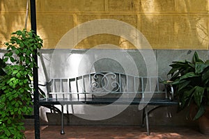 Beautiful Wrought Iron Outdoor Bench against Mediterranean Bisque color wal