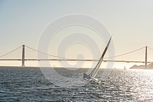 Beautiful yacht in San Francisco bay at sunset, Golden Gate bridge on the horizon