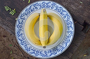 Beautiful yellow ripe skin of canvedish bananaes, strange arrangement in ceramic dish