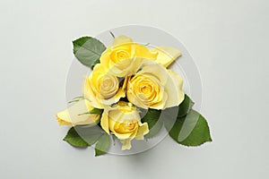 Beautiful yellow roses on light grey background, flat lay