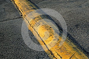 A beautiful yellow speed bump jutting across the parking lot.