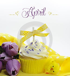 Beautiful yellow Spring or Easter theme cupcake with seasonal flowers tulips and decorations for the month of April
